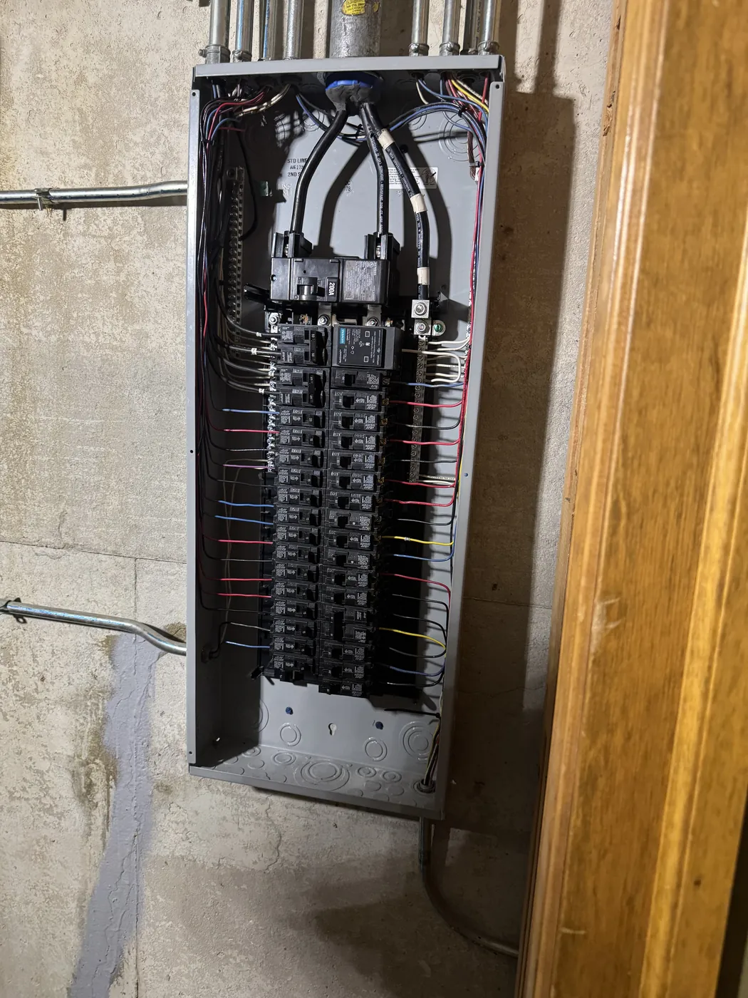 Open electrical service panel with newly wired breakers by Tritan
