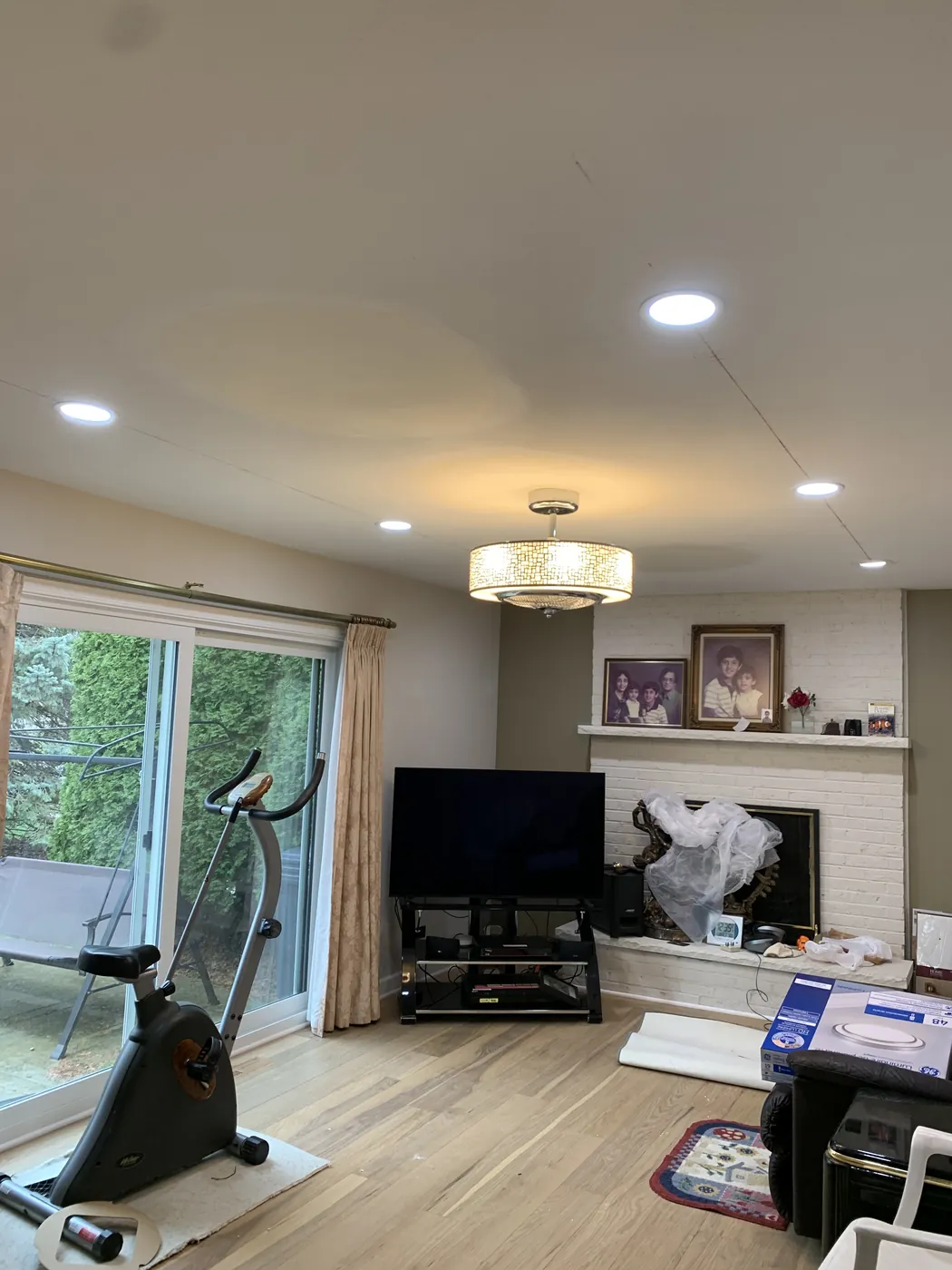 Recessed lighting and a ceiling fixture in a living room by Tritan