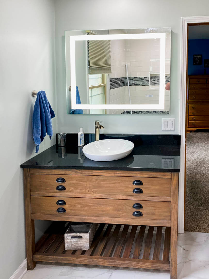 Bathroom vanity mirror with integrated lighting installed in a customer home