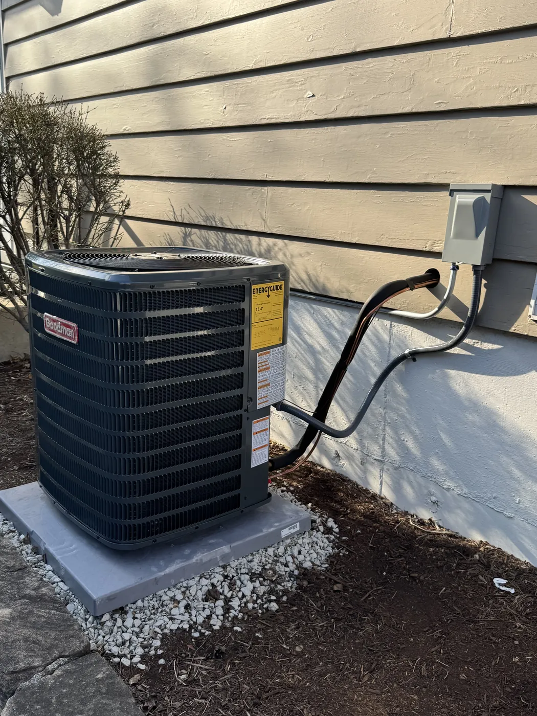 New outdoor AC condenser on a concrete pad installed by Tritan