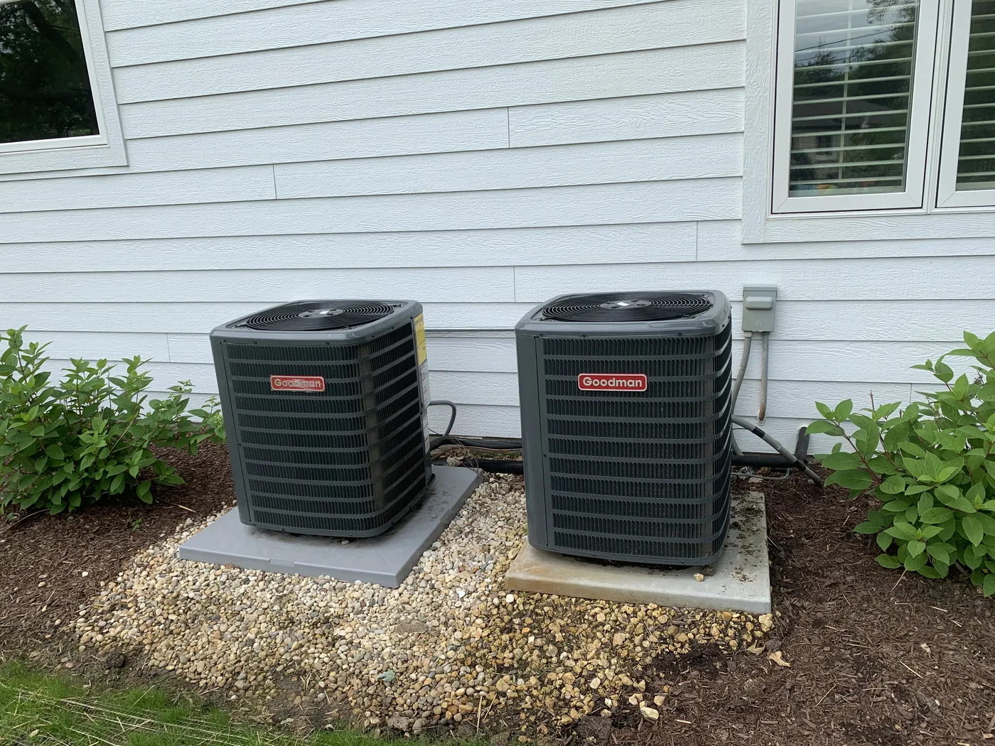 Two new AC condenser units installed by Tritan beside a home