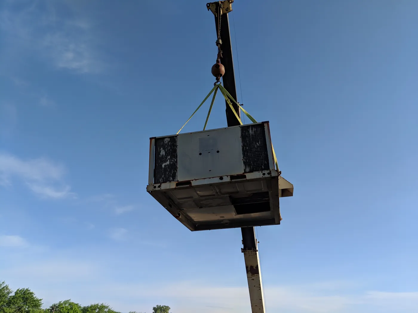 Rooftop HVAC unit lifted by crane during a commercial install by Tritan