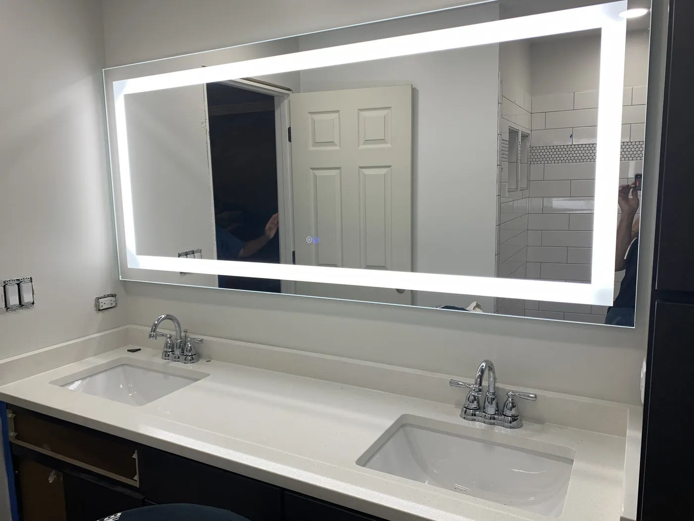 Double vanity with a wide LED mirror installed by Tritan