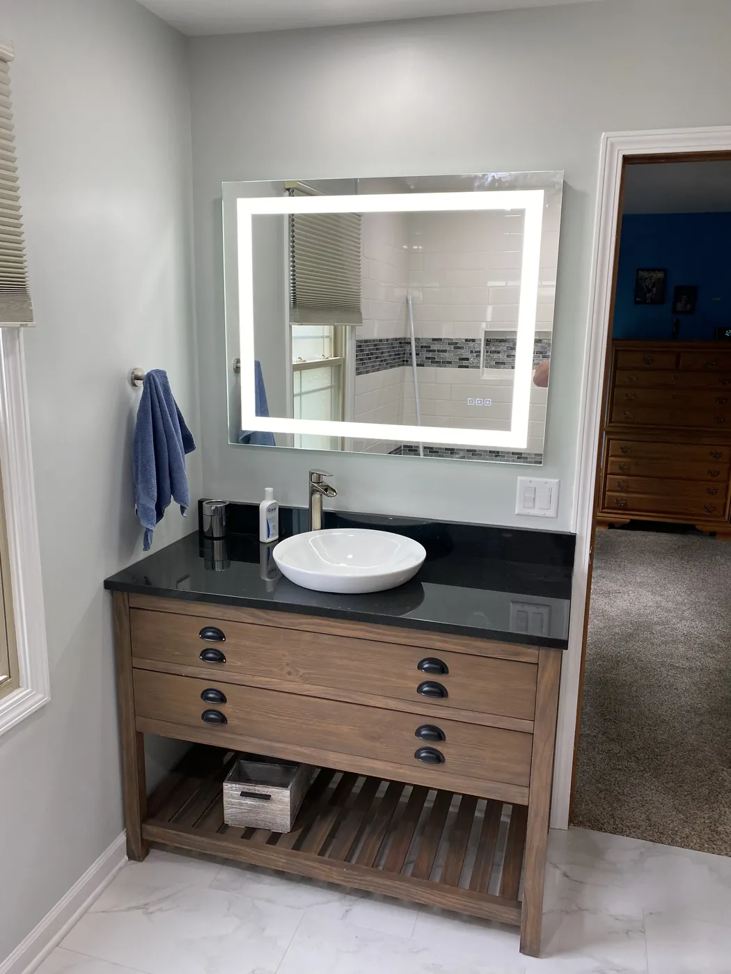 Bathroom vanity with a vessel sink and lighted mirror by Tritan