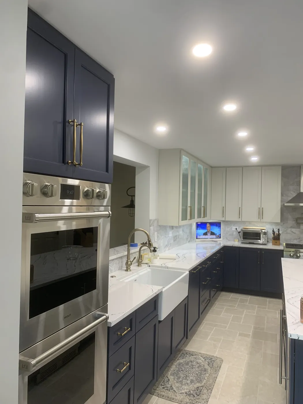 Navy kitchen with a farmhouse apron sink installed by Tritan