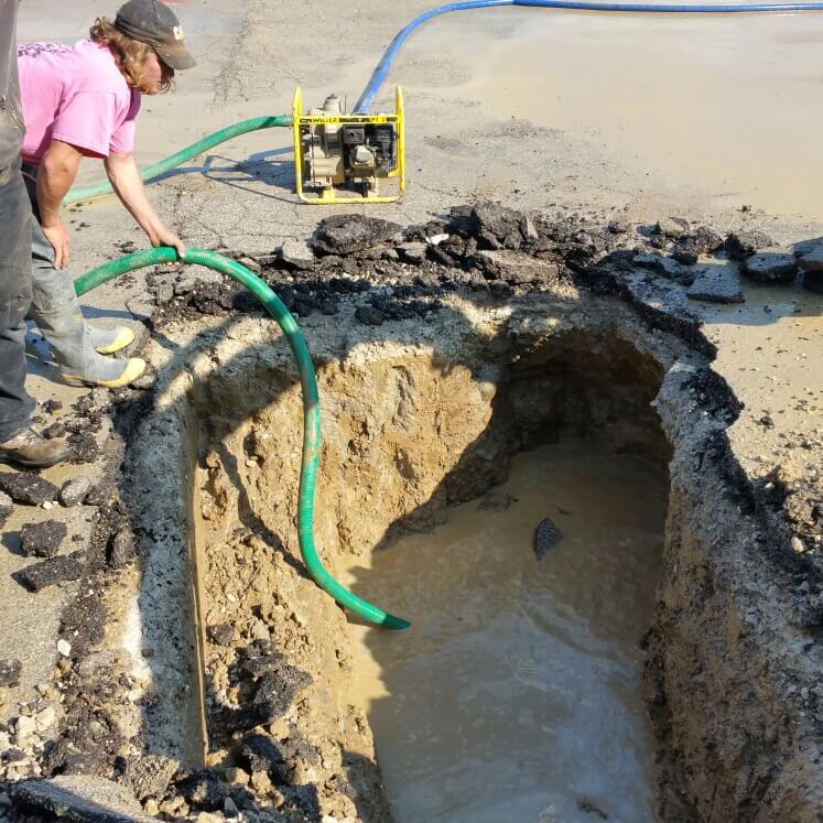 Tritan technician repairing water main in trench - Naperville plumbing service